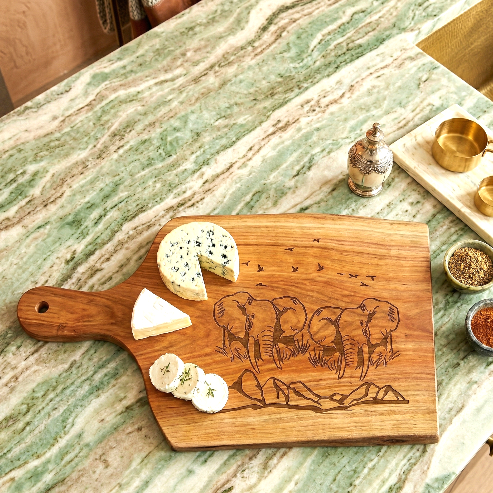 Wooden cutting board with elephant design on a marble countertop